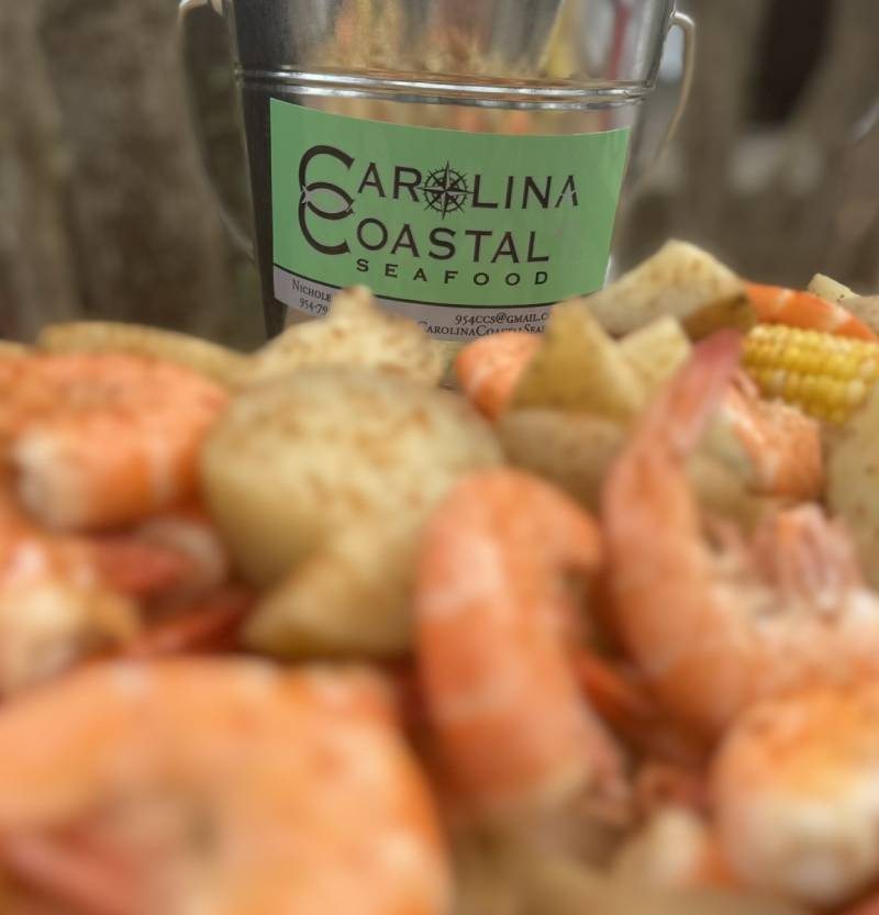 a large bowl filled with a variety of seafood, including shrimp and corn