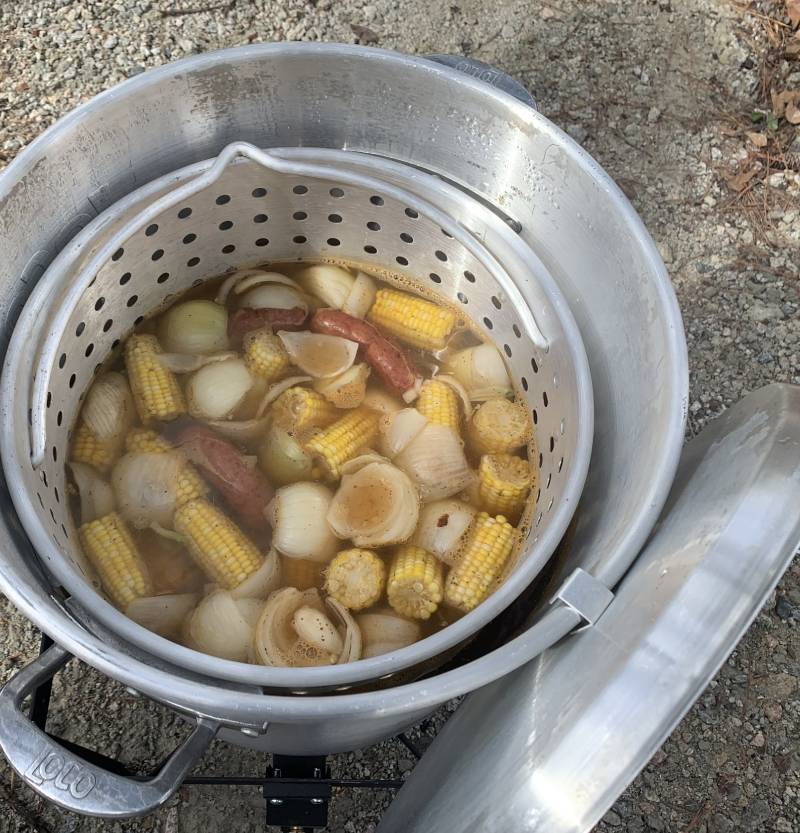 large pot filled with a variety of vegetables and meat, placed on a stove